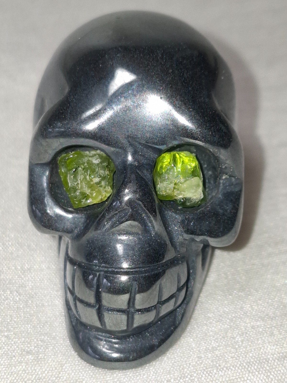 Hematite Skull with Peridot Eyes Hand Carved and Polished Hematite Skull with Peridot Eyes Hand Carved and Polished
