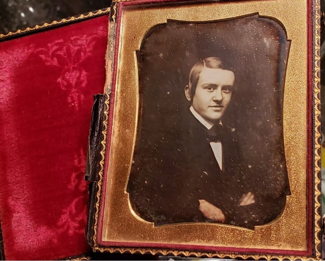 Quarter plate daguerreotype somewhat smiling young man trashed case