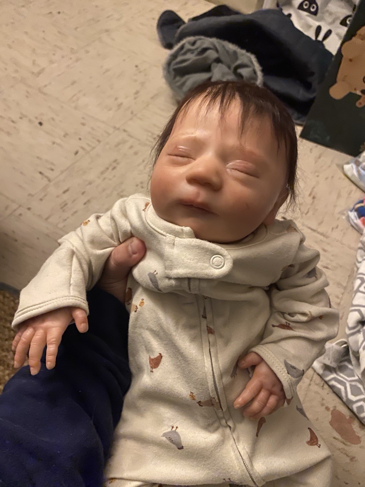 Realborn Caspain asleep with soft brown rooted hair