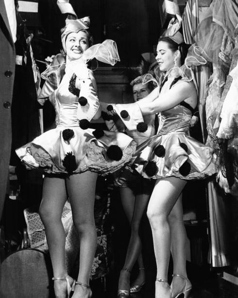 A costumed revue dancer arranges close partner\'s costume backstage- Old Photo