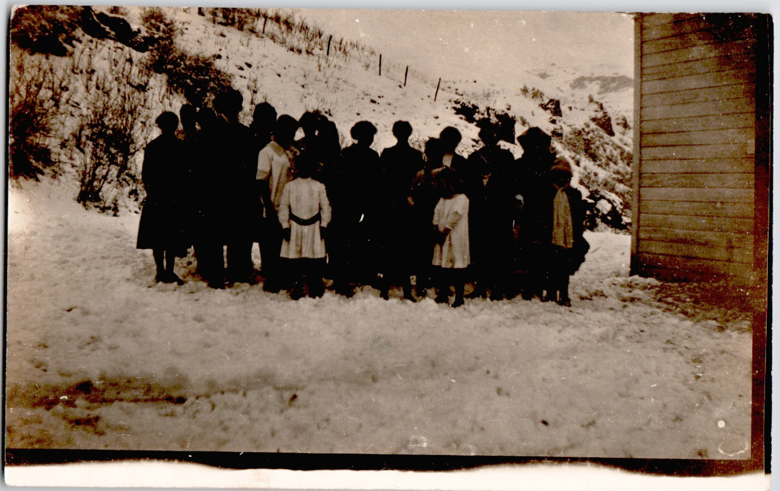 c1909 Large Group of Children Women on Snowy Hillside RPPC Postcard Winter Scene
