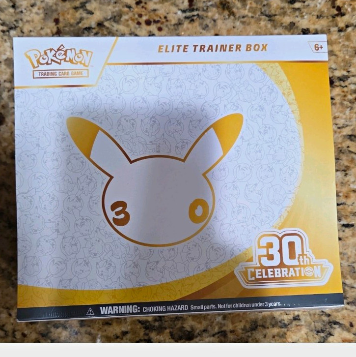 Pokémon TCG 30th anniversary Celebrations Elite Trainer Box In hand with slabs
