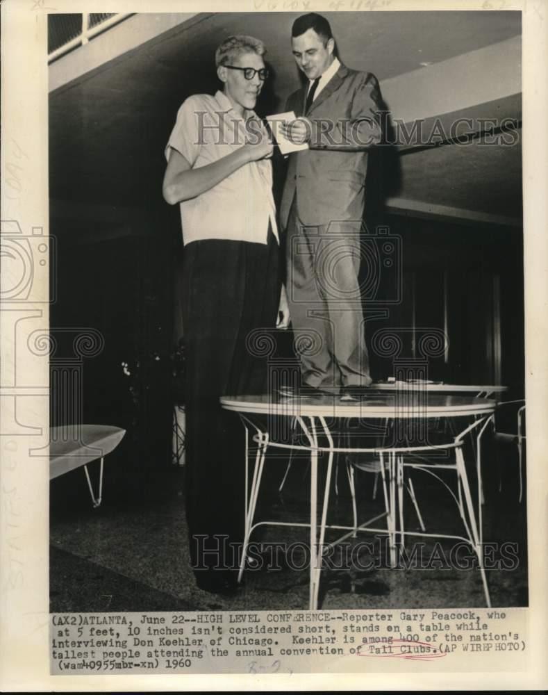 1960 Press Photo Gary Peacock on table to interview Tall Club member Don Koehler