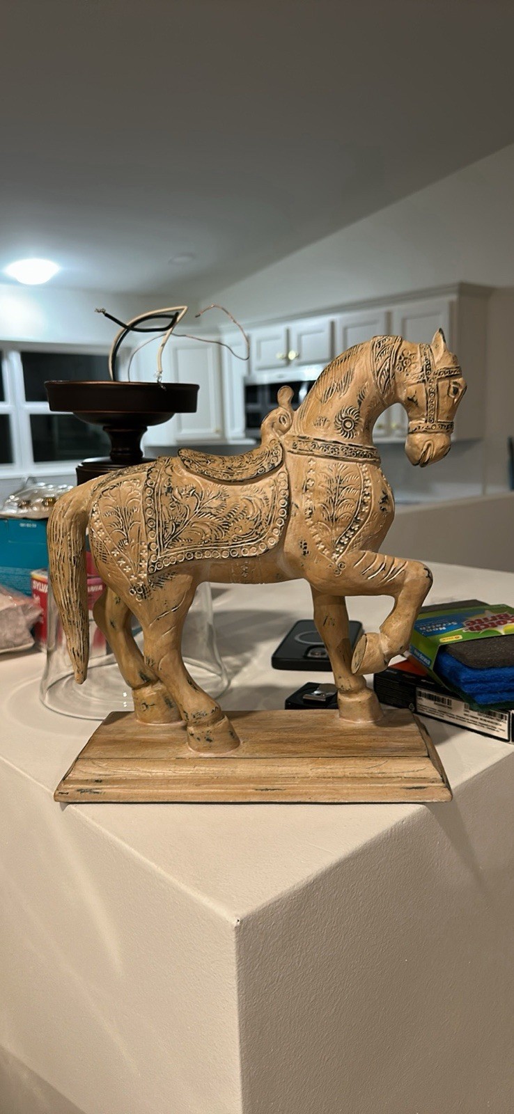 A carved Indian/Rajasthani-style wooden horse, with ornate floral