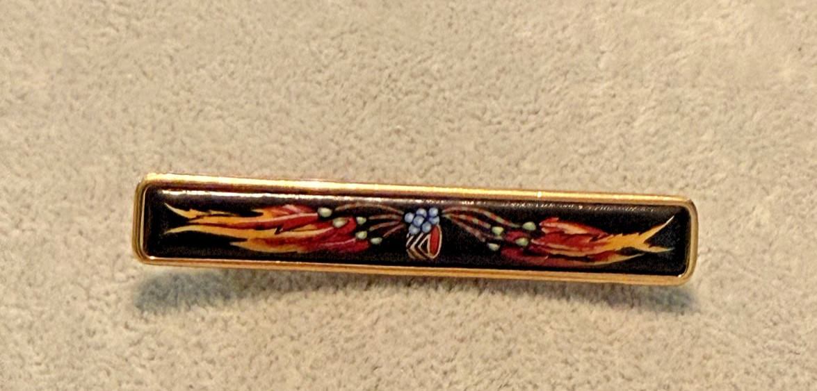 vintage Hermes enamel bar brooch featuring a vibrant red, blue, and gold JB1 vintage Hermes enamel bar brooch featuring a vibrant red, blue, and gold JB1