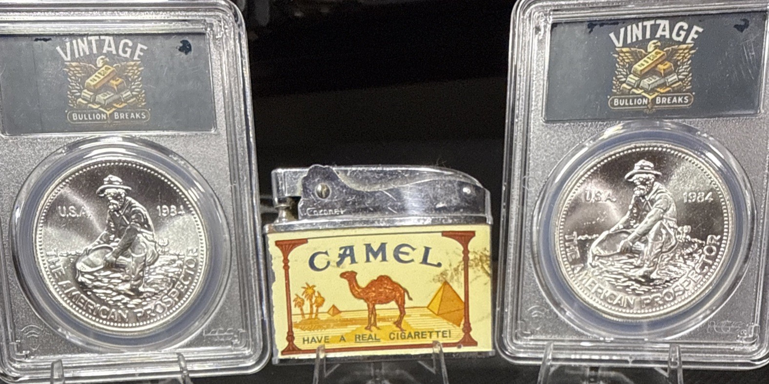 Two 1984 Engelhard Prospector Silver Rounds And A Vintage Camel Lighterš„ Two 1984 Engelhard Prospector Silver Rounds And A Vintage Camel Lighterš„
