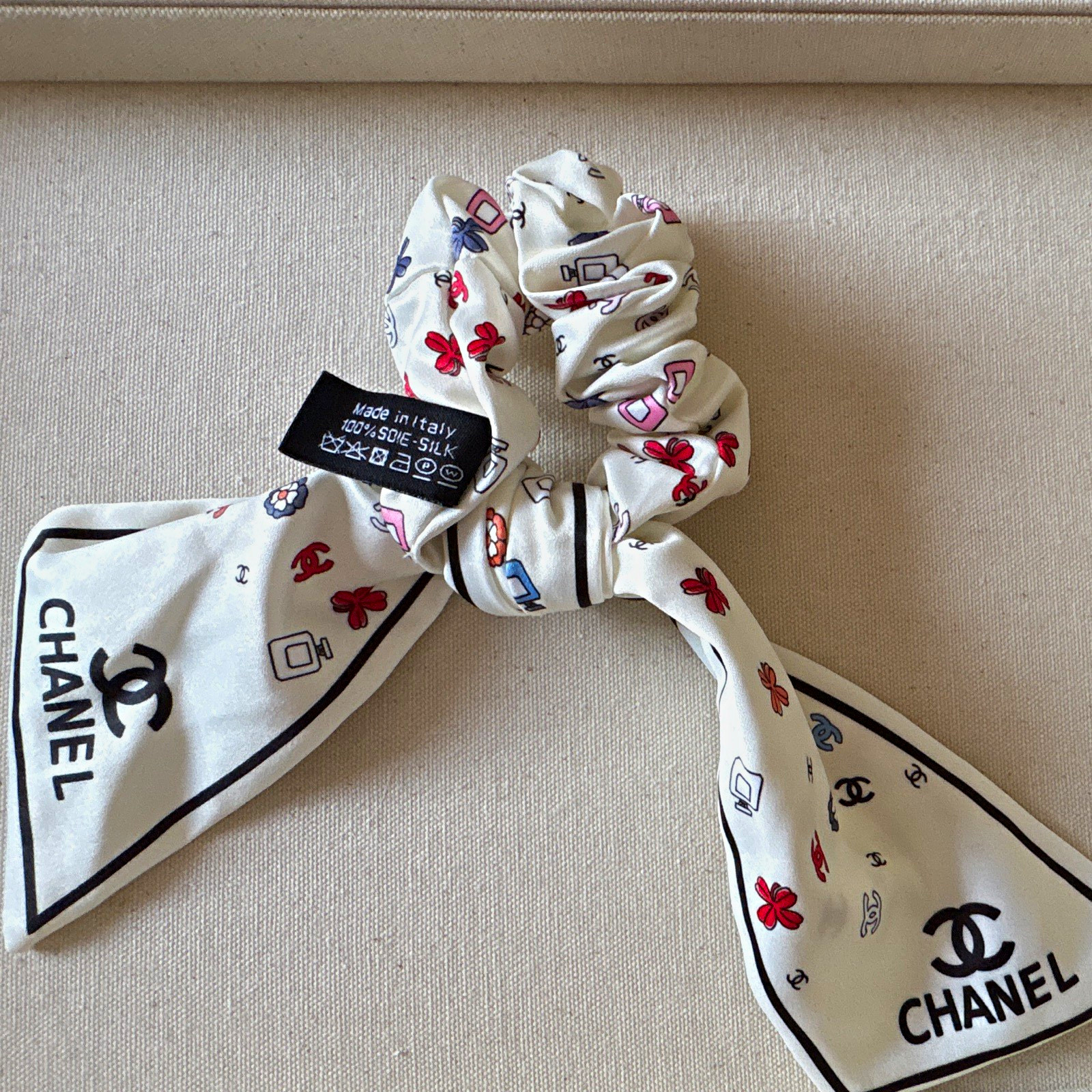 CHANEL Women’s White/Black Logo Silk Print Scrunchie Hair Tie with Scarf Tails CHANEL Women’s White/Black Logo Silk Print Scrunchie Hair Tie with Scarf Tails