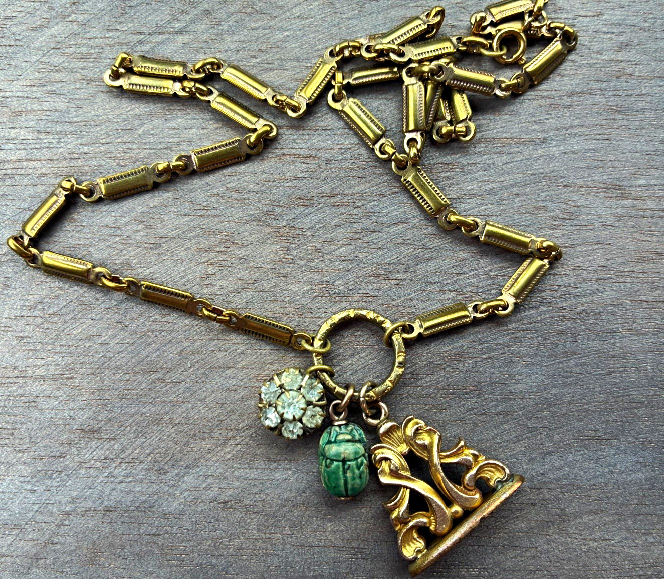 Antique gold filled ornate fob with antique Victorian charms on fancy chain