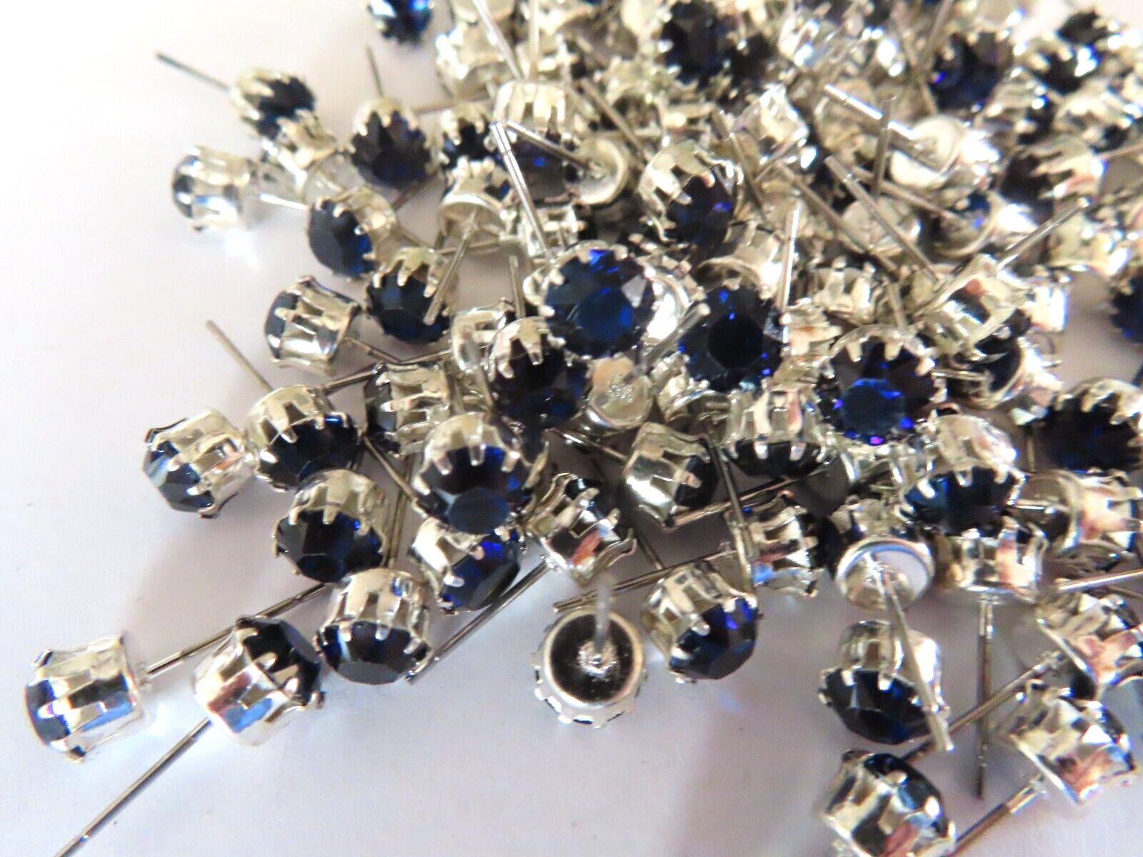 24 Swarovski Rhinestone 29ss Dk. Sapph/tiff. set sterling plate post earrings. 24 Swarovski Rhinestone 29ss Dk. Sapph/tiff. set sterling plate post earrings.