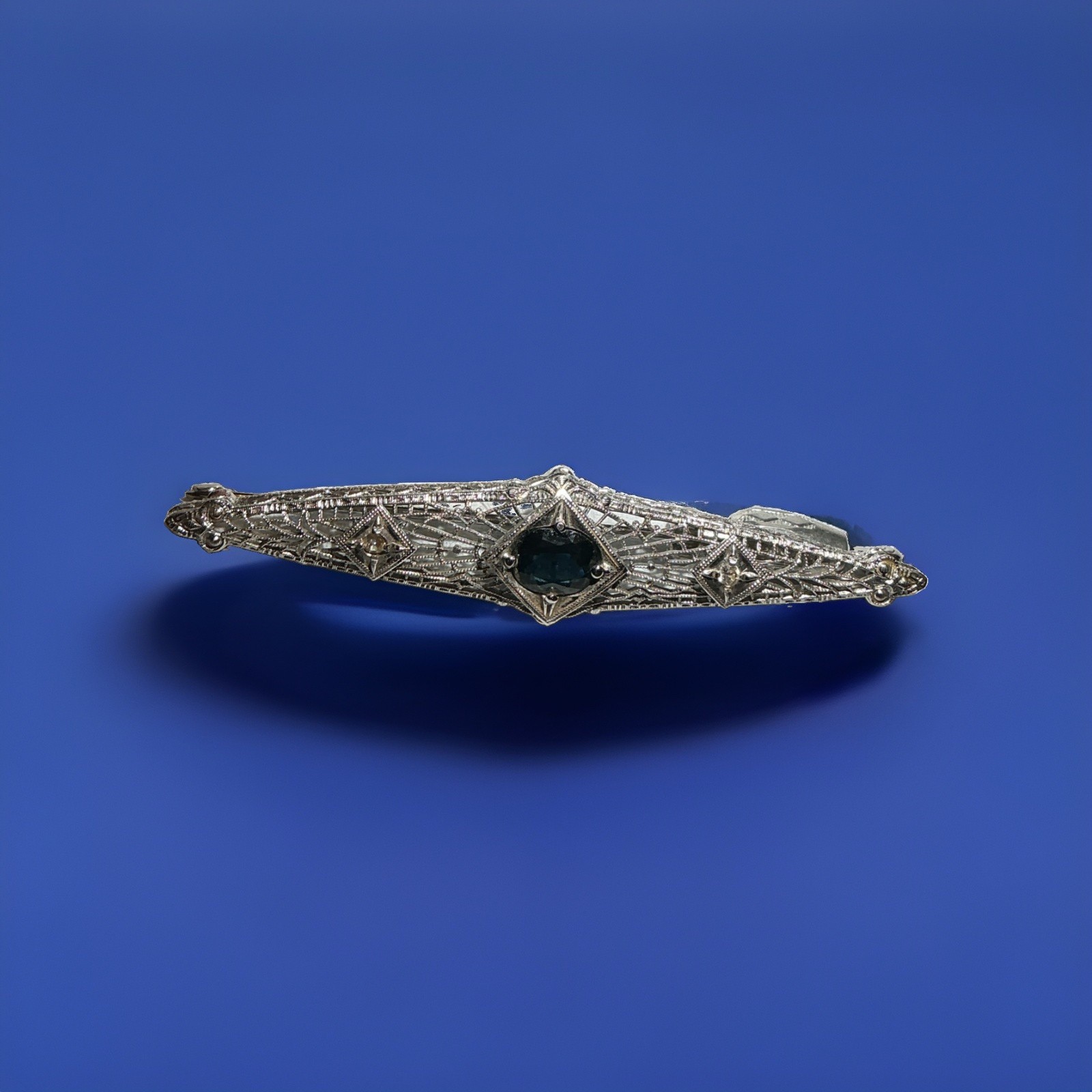 Filigree Brooch in 14k white gold with a 1.13ct Sapphire and 2 .06ct diamonds