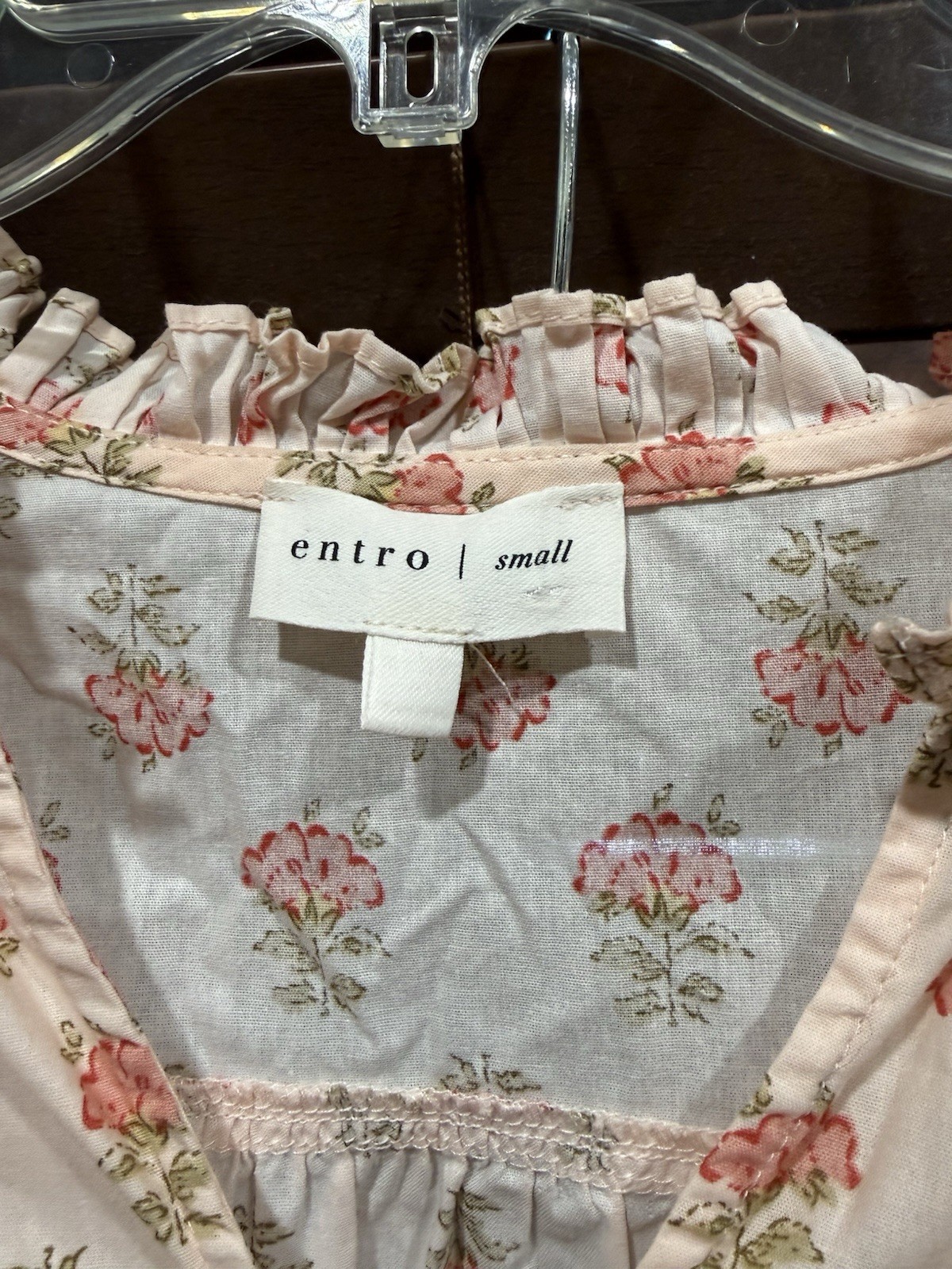 This garment is a pink floral-print small top by Entro/ ruffled collar. This garment is a pink floral-print small top by Entro/ ruffled collar.