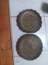 This is a vintage embossed brass plate featuring an intricate floral design picture