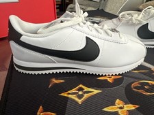 Nike Cortez sneakers featuring a smooth white upper and a distinct black Swoosh  picture