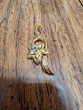 New gold toned pendant with rhinestone in the flower.  picture