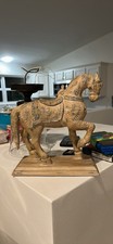 A carved Indian/Rajasthani-style wooden horse, with ornate floral picture