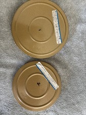 two vintage DUAL 8 mm film reels in their protective storage cans, labeled picture