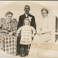c1910s Family Porch Portrait RPPC Plaid Dress Wicker Chair Eyeglasses Postcard picture