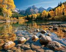Golden Aspen River with Rocky Shallows Below Snowy Peaks Print - 724964374 picture